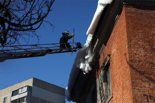 МНСники розчищають дах від льоду і снігу