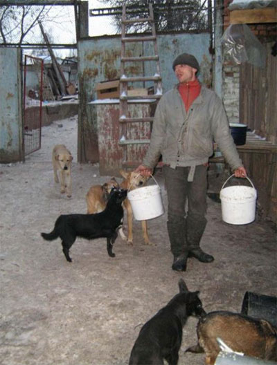 Доглядач вінницького притулку для тварин Юрій, виносить пісну кашу для собак.