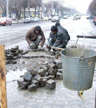 Працівники приватної фірми перекладають бруківку навпроти міськвиконкому у Вінниці