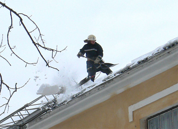 працівники МНС чистять дах дитячого садочку від снігу