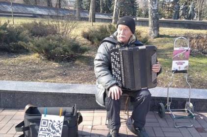 Вуличний музика приймає гроші за виступ через QR-код Вуличний музика приймає гроші за виступ через QR-код