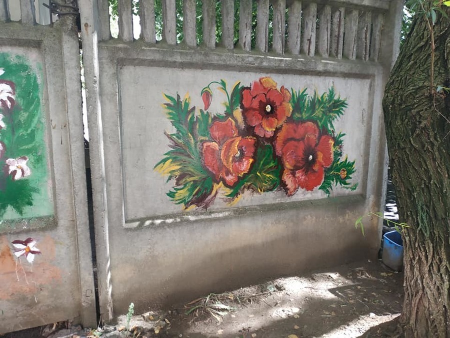 Вінничанка розфарбовує паркан в дворі багатоповерхівки яскравими картинами